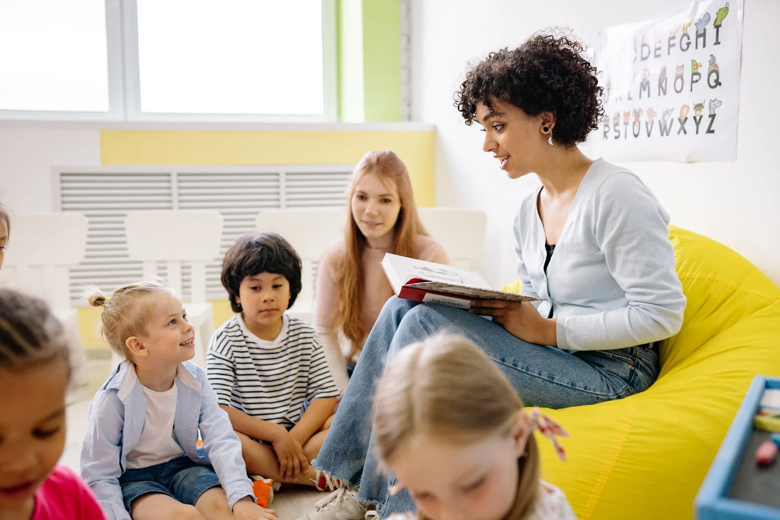 Teacher reading with children, illustrative stock photography for the fictional preschool