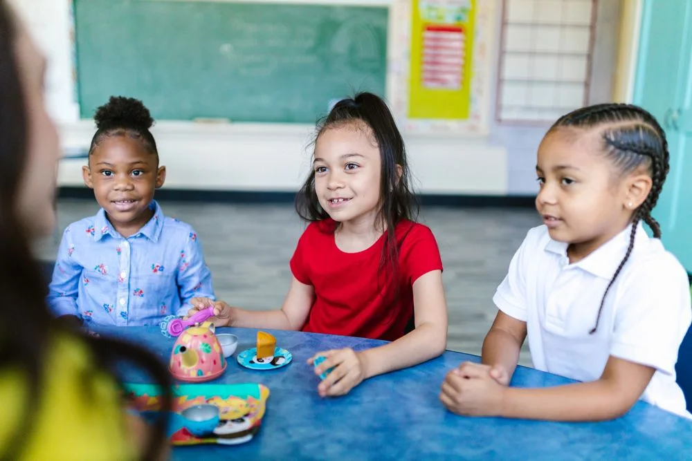 Children exploring together at a table, illustrative stock photography